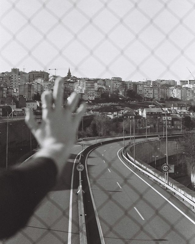 mano sobre una valla con paisaje urbano al fondo